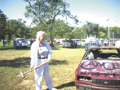 Daily Journal reporter, Paula Barr, takes a swing at a car to raise money for Relay for Life of St. Francois County Saturday at the Leadwood Fall Festival. - Jessica Crepps | Daily Journal